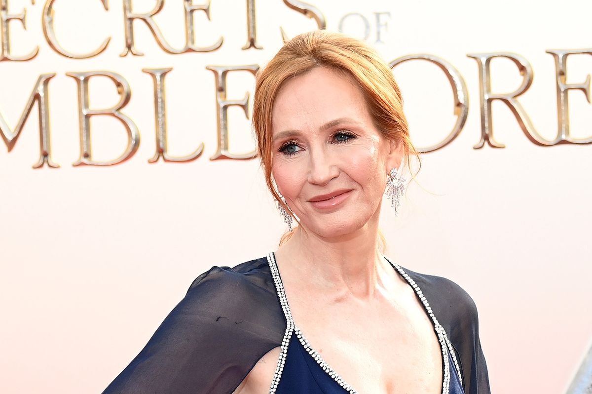 J.K. Rowling in a blue dress on a red carpet.