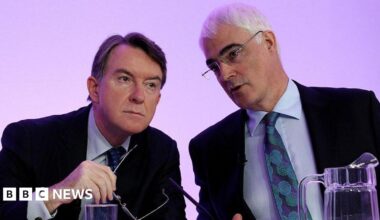 Former Business Secretary Peter Mandelson, wearing a dark suit jacket, light shirt and dark patterned tie sits on the left of former chancellor Alistair Darling, wearing a dark suit jacket, light blue shirt and turquoise and dark blue tie