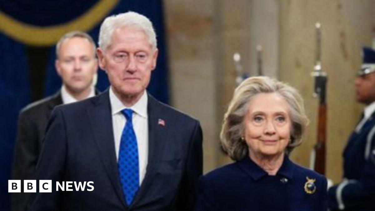 Former President Bill Clinton lays in a hot tub. Sitting next to him is a person whose face has been redacted