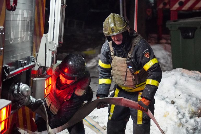 Ukrainian emergency workers are seen at the site of an apartment building that was damaged following a Russian air attack in Kyiv