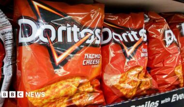 A bag of Doritos Nacho Cheese flavour. the packaging is bright red