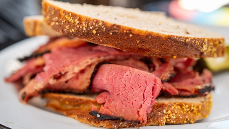 Pastrami on rye sandwich on a white plate