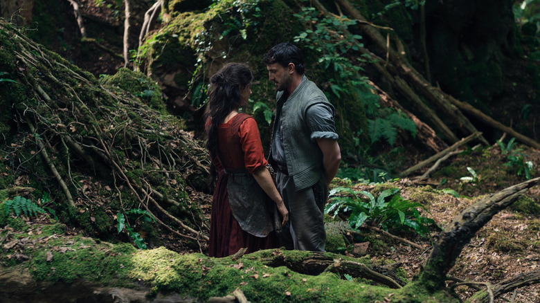 Jessie Buckley as Agnes Hathaway and Paul Mescal as William Shakespeare standing together in a forest in Hamnet