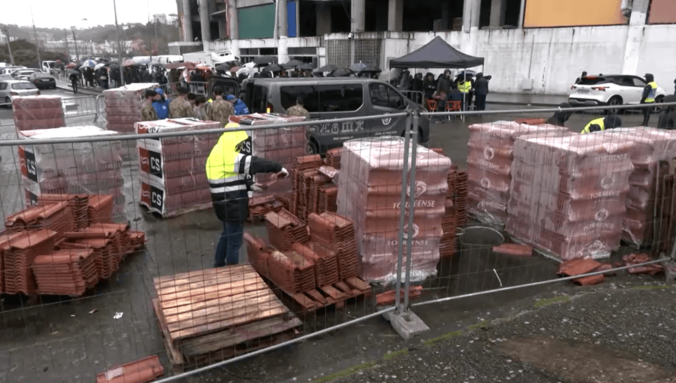 Locals queue to collect roof tiles