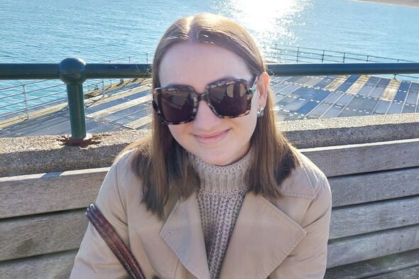 woman sat on pier next to sea