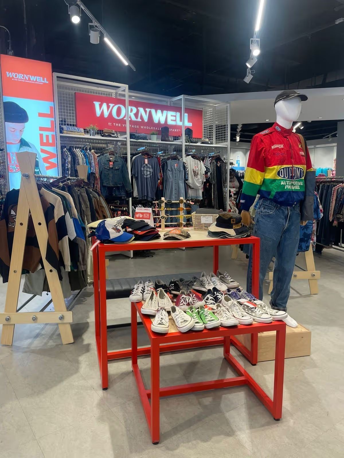 Vintage clothing on racks and tables in side Primark, Liverpool. A red sign in the background says "Wornwell"