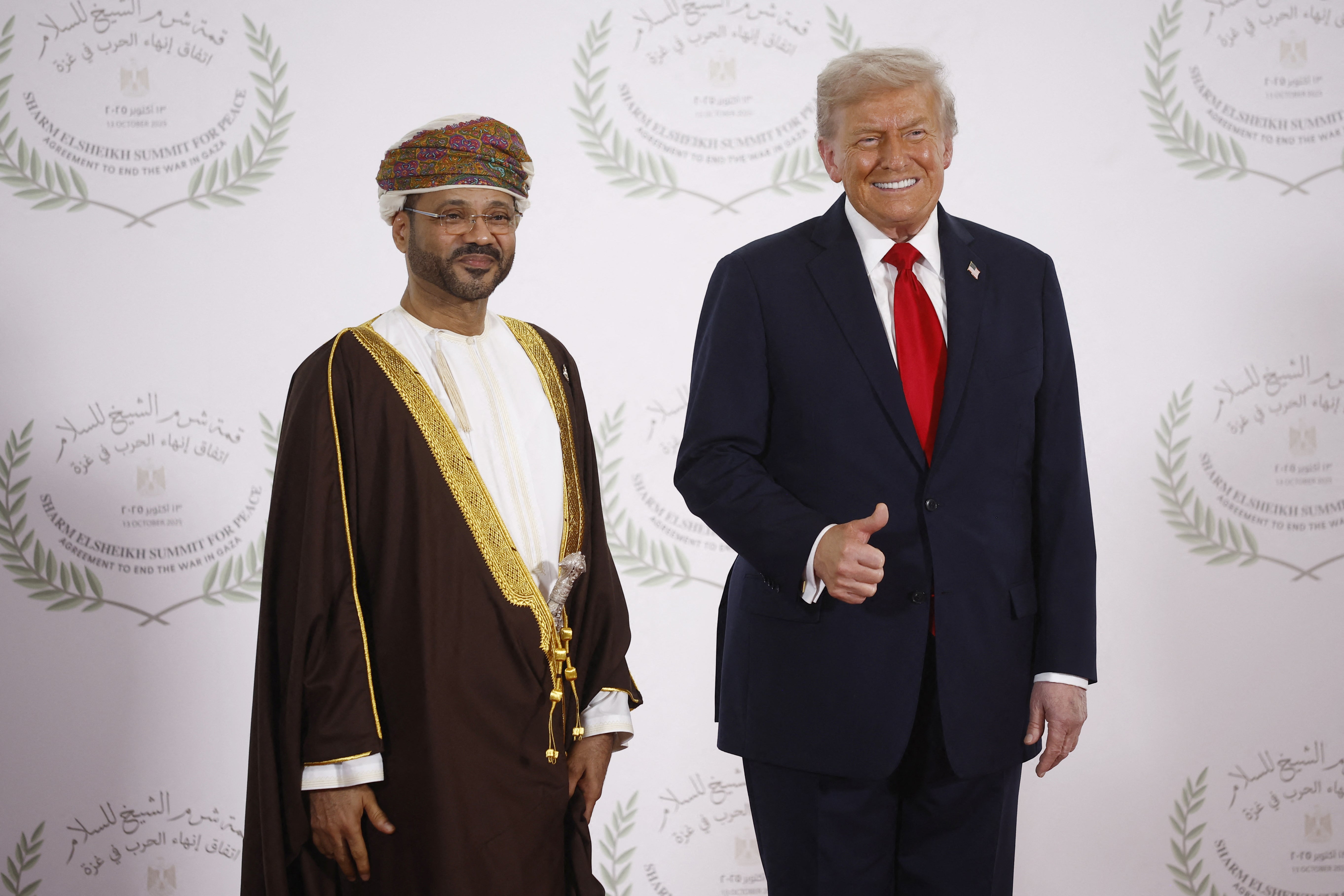 Oman's Foreign Minister Sayyid Badr Albusaidi (L) and US President Donald Trump pose during a summit on Gaza in Sharm el-Sheikh on October 13, 2025