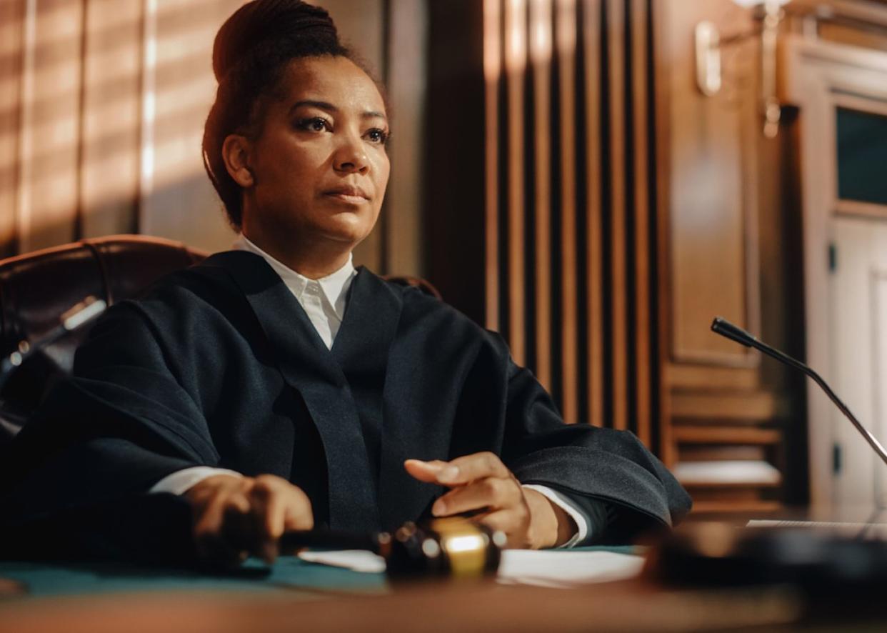 Woman judge with gavel in courtroom. -