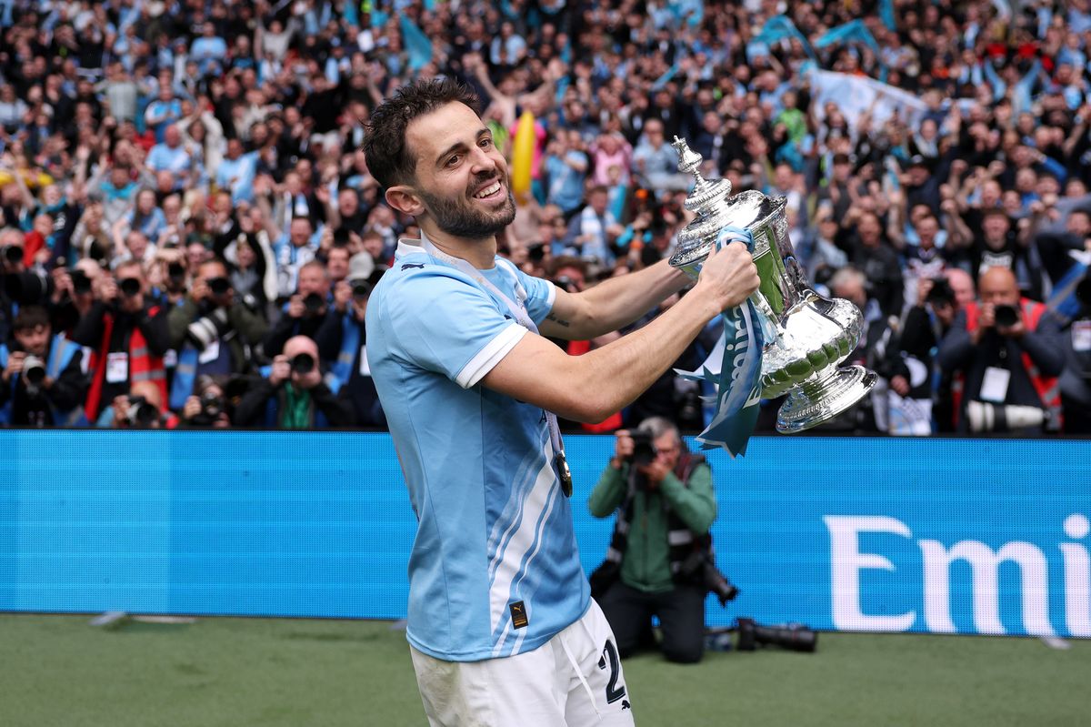 LONDON, ENGLAND - MAY 16: Bernardo Silva of Manchester City celebrates with the Emirates FA Cup trophy in front of the fans after the Emirates FA Cup Final match between Chelsea and Manchester City on May 16, 2026 in London, England. (Photo by Michael Regan - The FA/The FA via Getty Images)