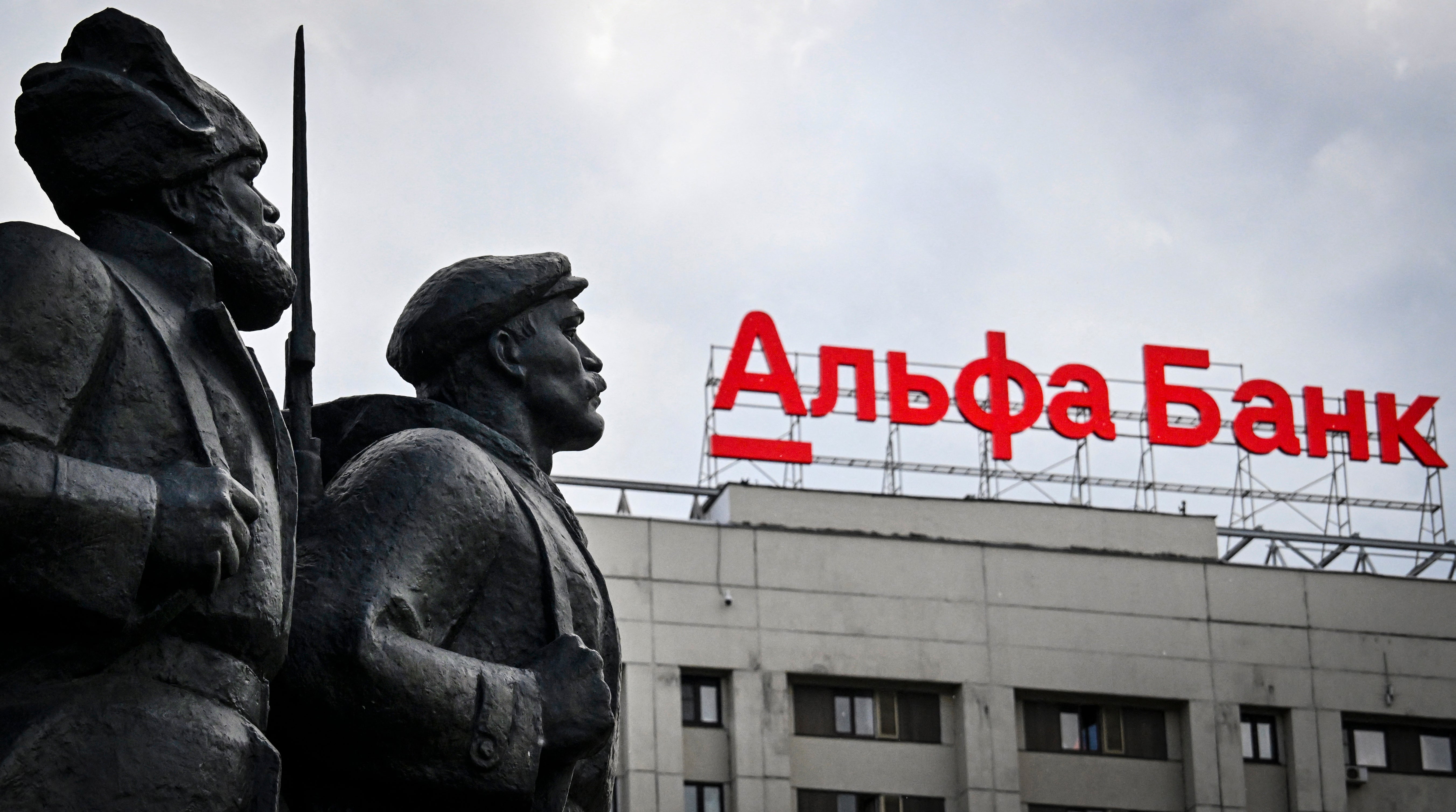 The logo of Alfa Bank, Russia's privately-held lender is seen atop of a building behind revolutionary militiamen in Moscow
