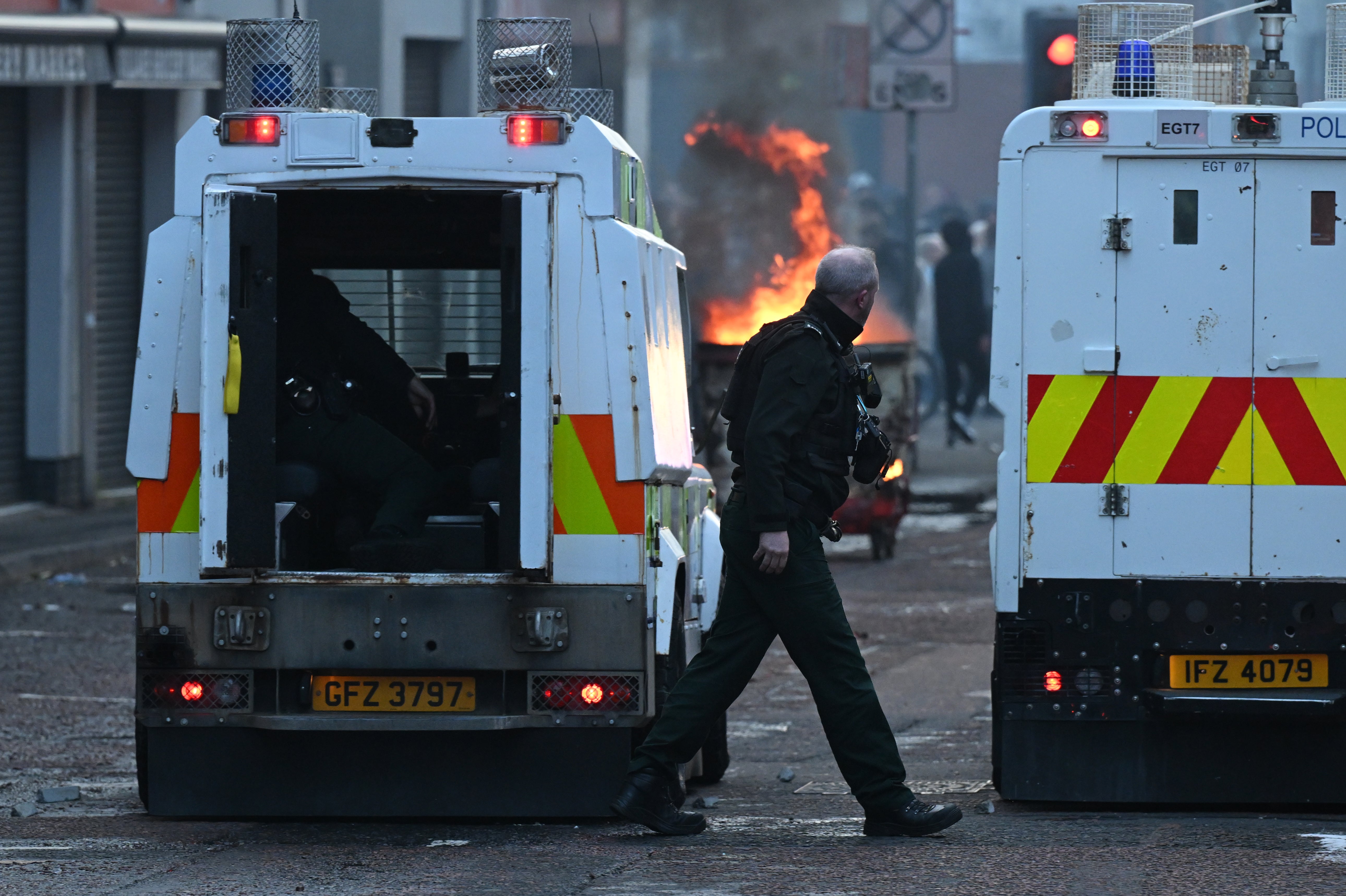 Police officers take cover from protestors on Sandy Row on June 9