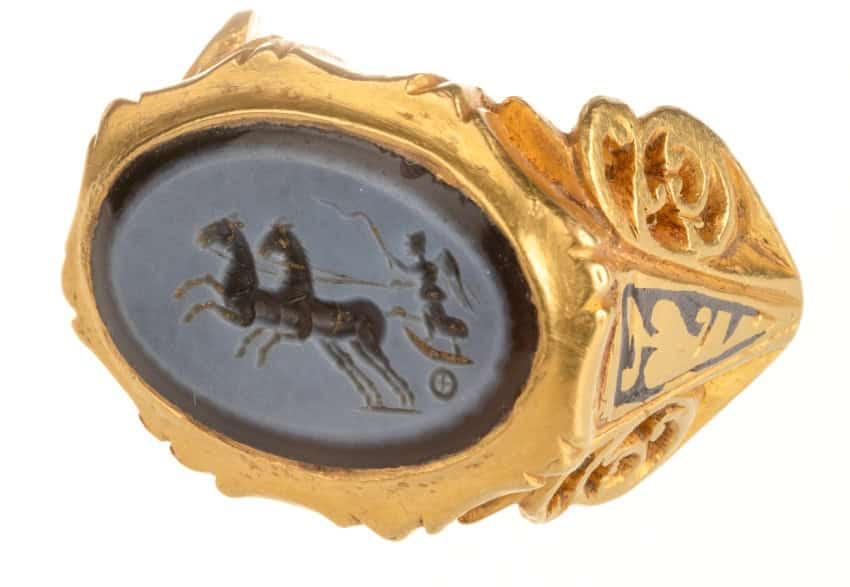 Ancient Greek gold signet ring featuring an engraved horse and chariot scene, showcasing classical c.