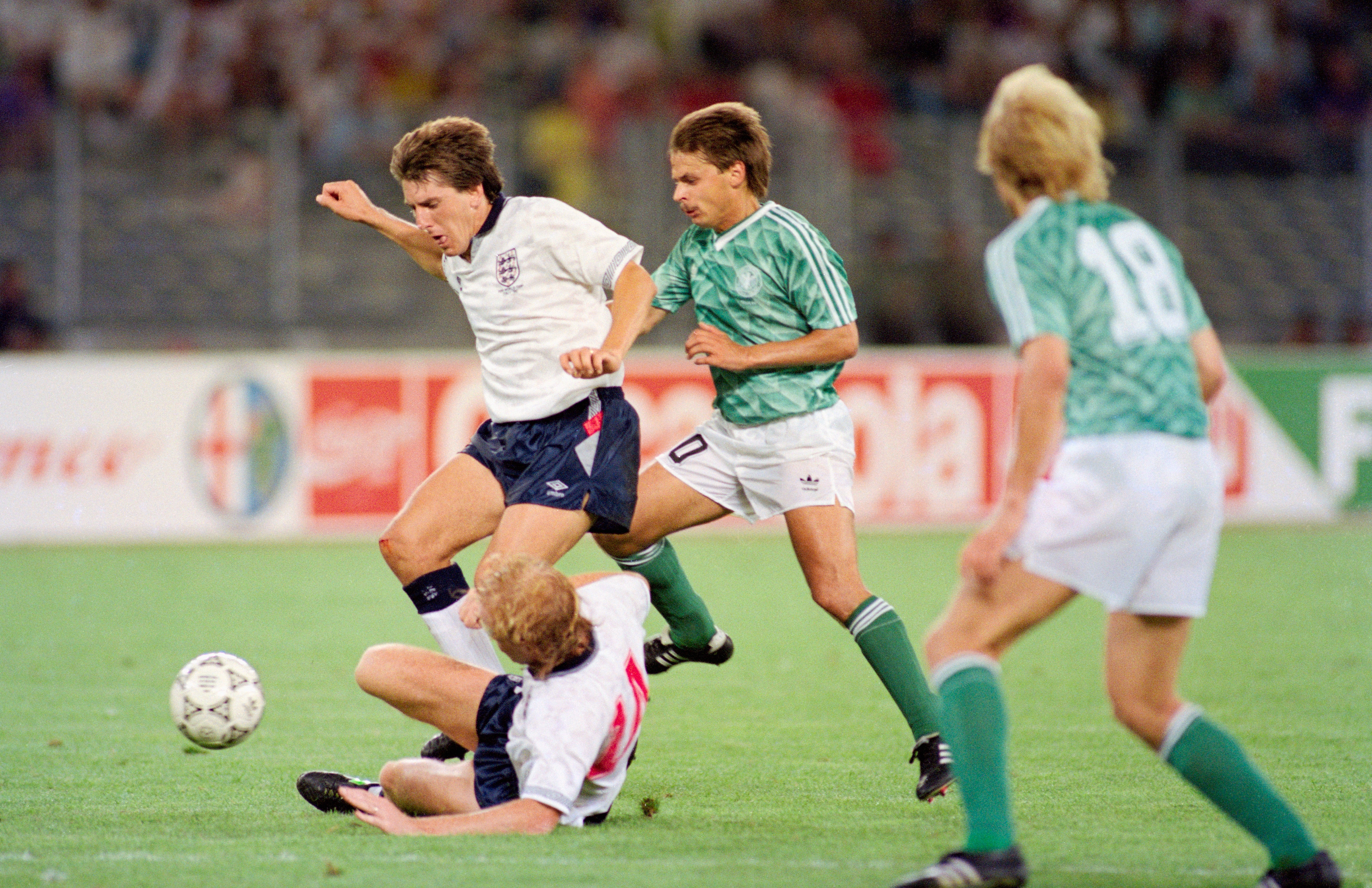 England players Mark Wright (floor) and Peter Beardsley combine to thwart Olaf Thon of West Germany during the 1990 FIFA World Cup Semi Final