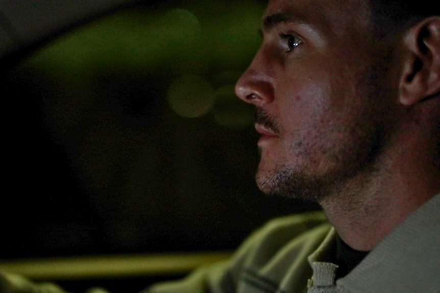 Close-up Luke Bateman's face as he drives a car at night.