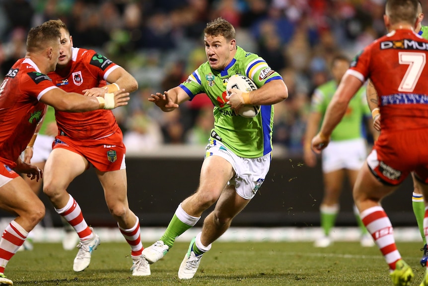 NRL player Luke Bateman sidesteps opponents during a rugby league game.