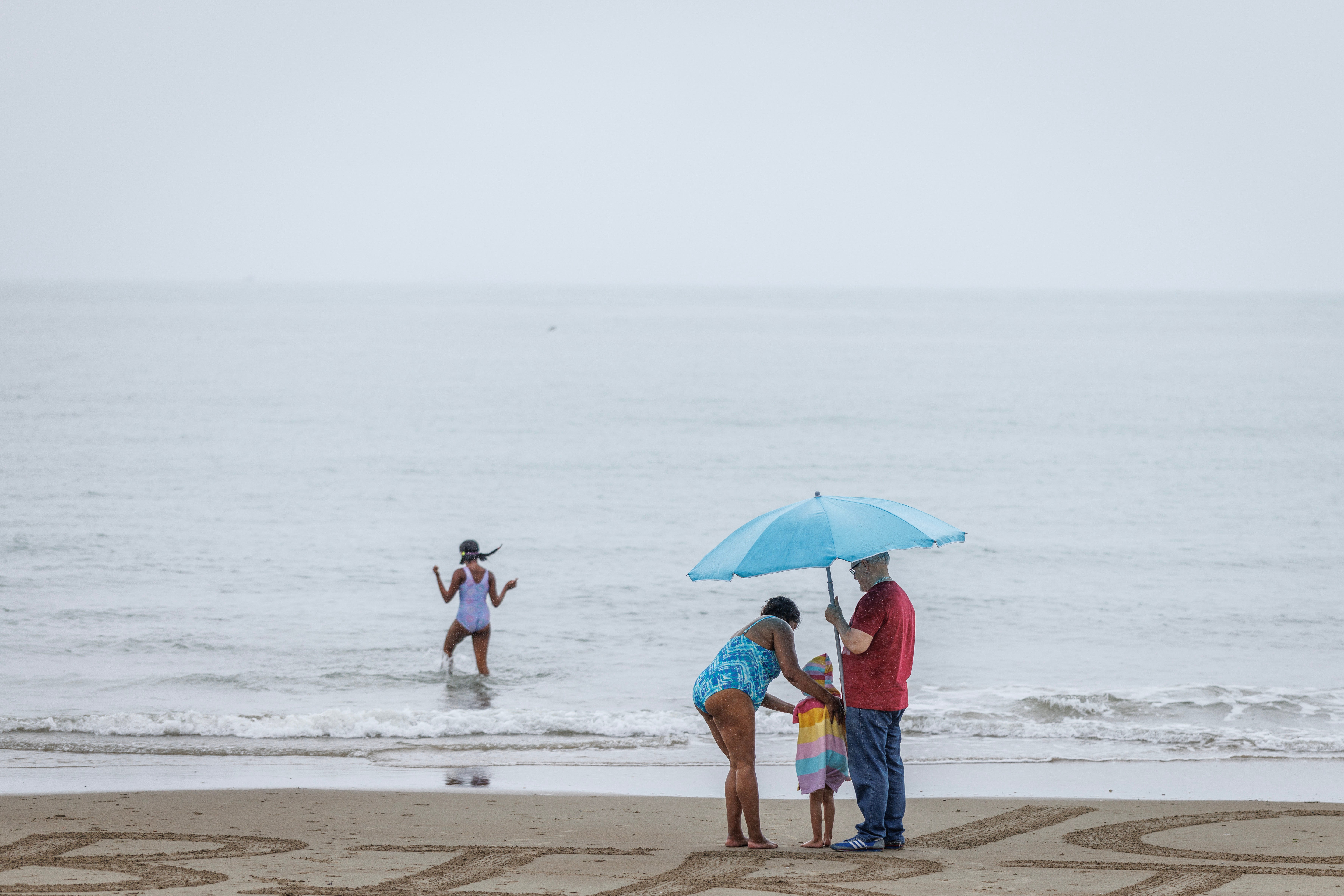 People under an umbrella in the rain on Sunny Sands Beach in Folkestone last week