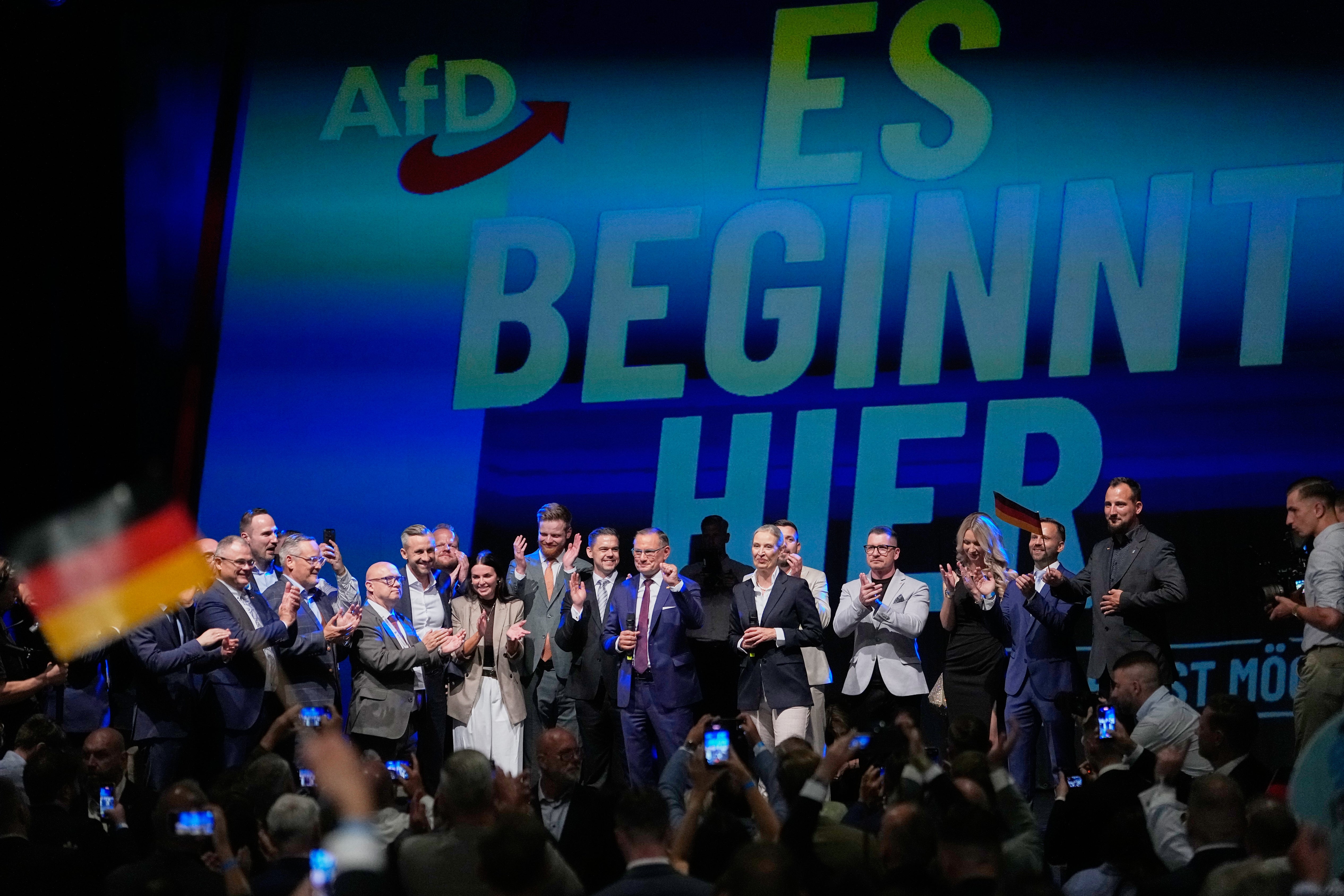Top candidate Ulrich Siegmund and party leaders Tino Chrupalla and Alice Weidel, speak to party members in front of a reading 