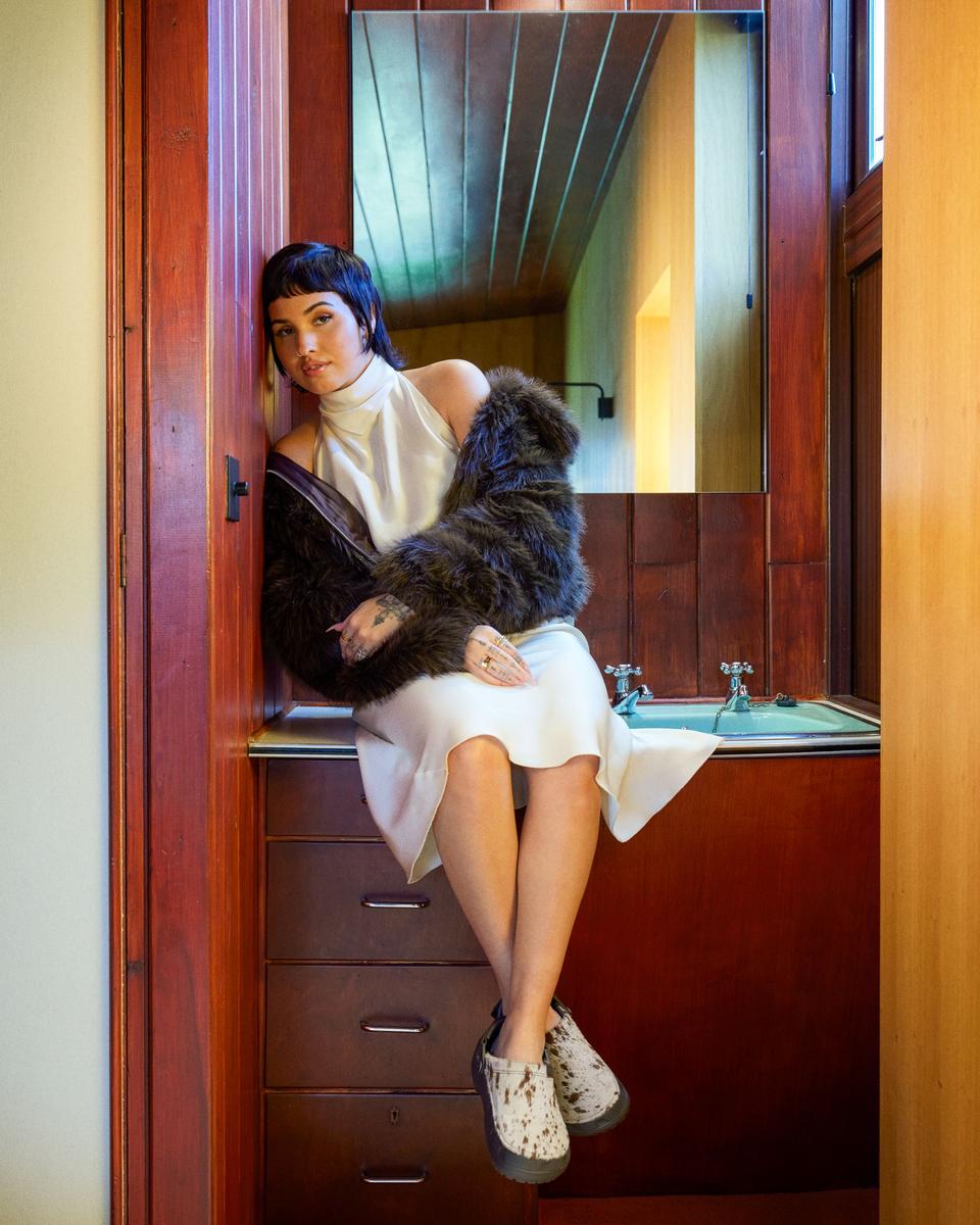 Mabel sits on top of a sink for a photoshoot