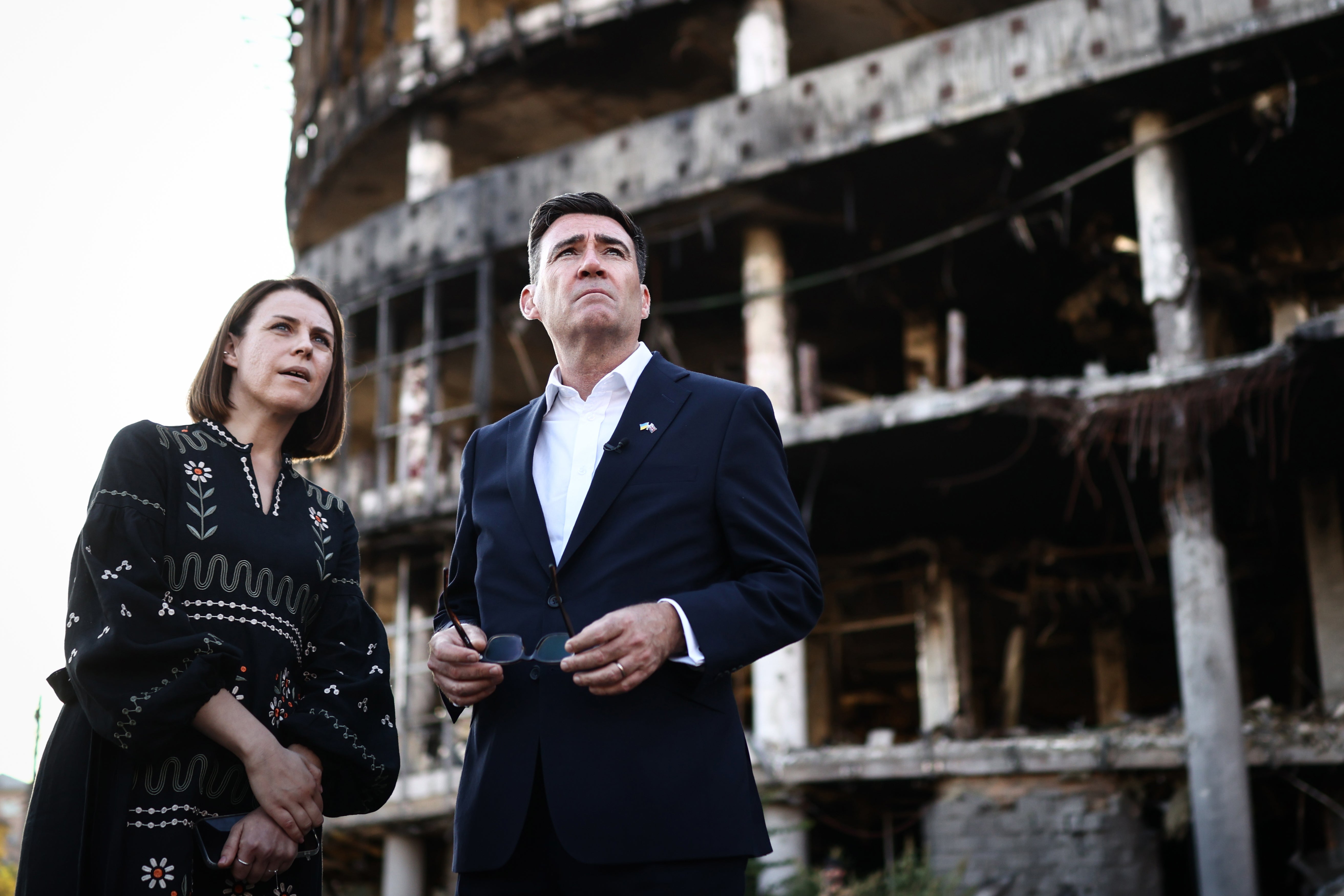 Andy Burnham reacts as he is shown the damage of the buildings and site of a strike at Lukanivska market
