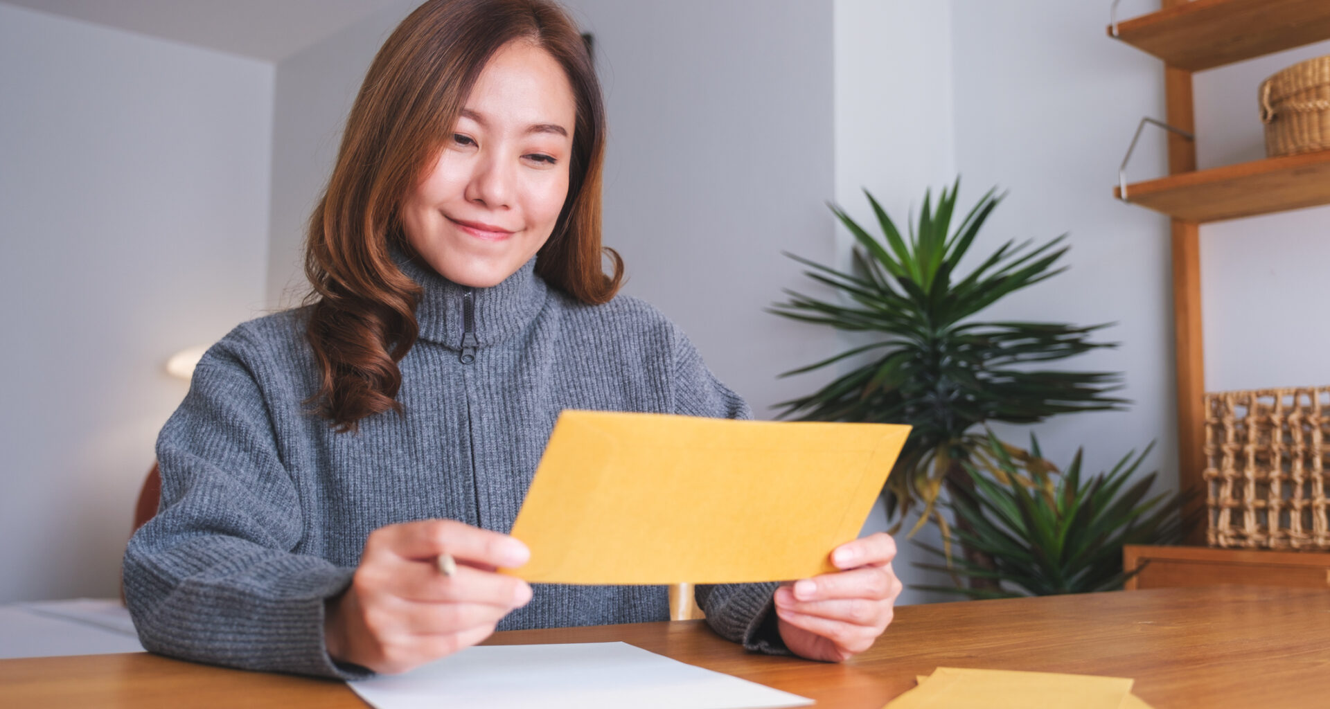 A stock image of woman reading card.