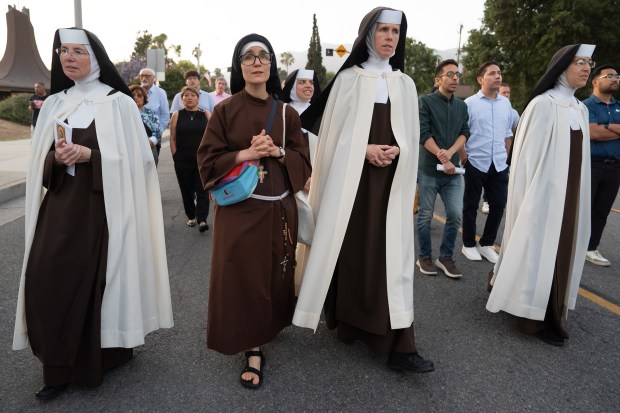A group of religious sisters participate in the procession through...