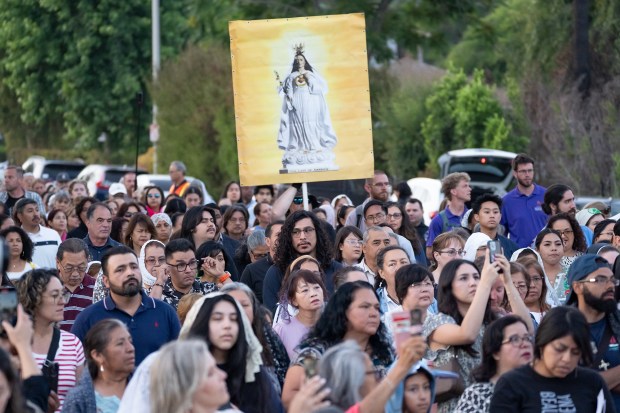 Attendees and members of Sacred Heart Church join Archbishop José...