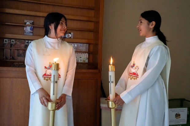 Candle bearers Gloria Gomez, left, and Pilar Hernandez chat before...