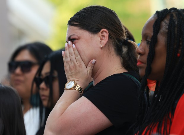 A mourner wipes away tears during a prayer vigil for...