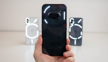 Holding the Nothing Phone (2a) with Nothing Phone (1) and Nothing Phone (2) in the background