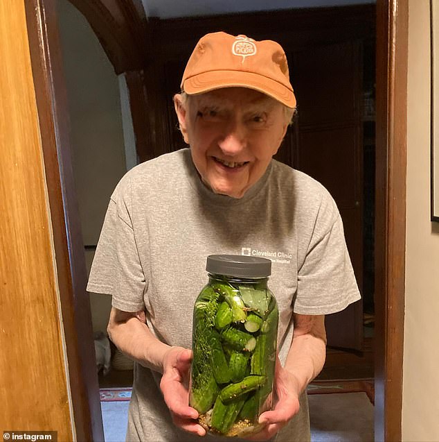 Dr Tucker is pictured above with one of his snacks, pickles, which he likes to make himself by mixing brine with cucumbers