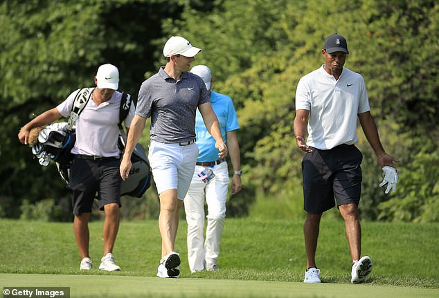 Woods pictured walking with Rory McIlroy during a practice round back in 2020