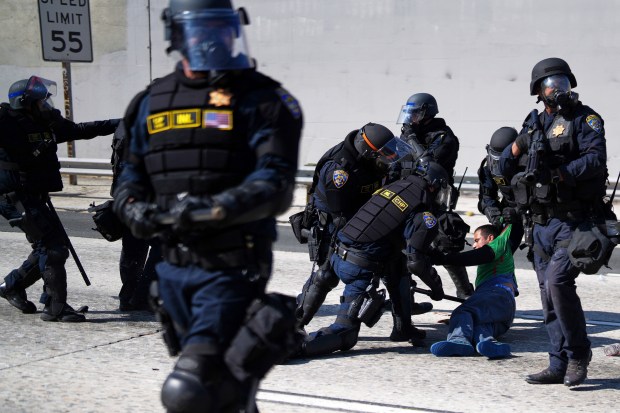A protester is detained on the 101 Freeway near the...