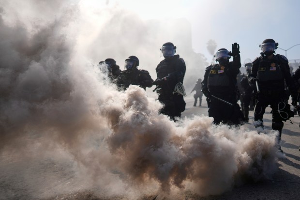 Police are seen through smoke on the 101 Freeway near...
