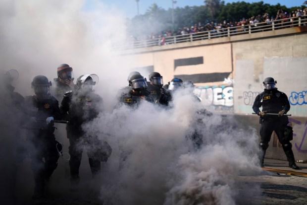 Police are seen through smoke on the 101 Freeway near...