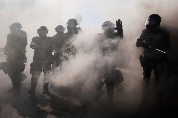 Police are seen through smoke on the 101 Freeway near...