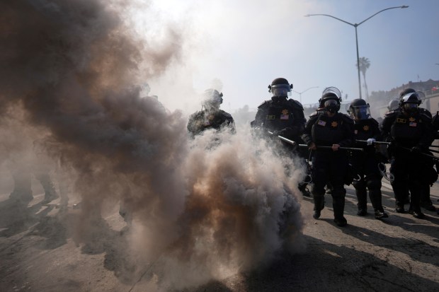 Police are seen through smoke on the 101 Freeway near...