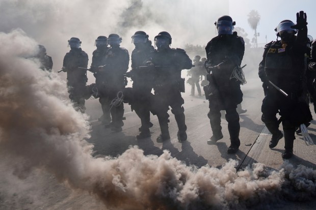 Police are seen through smoke on the 101 Freeway near...