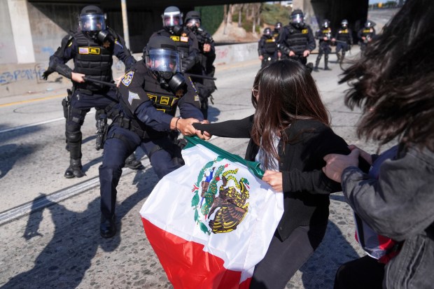 Protesters confront police on the 101 Freeway near the metropolitan...