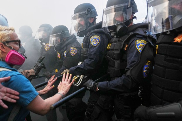 Protesters confront police on the 101 Freeway near the metropolitan...