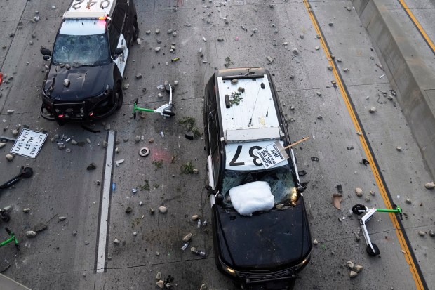 Vandalized police cars are seen on the 101 Freeway near...