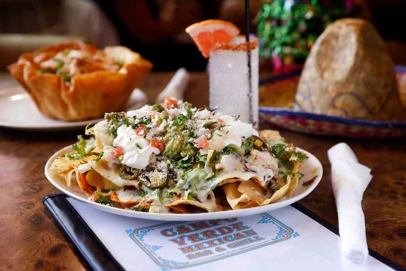 The nachos with braised chicken are served with a Reposado Paloma drink at Campo Verde, the...