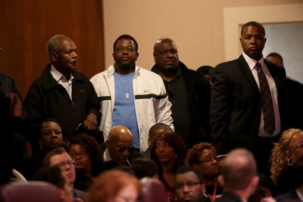 Victims of former Chicago police Cmdr. Jon Burge stand to be honored by Chicago City Council on May 6, 2015. (Nancy Stone/Chicago Tribune)