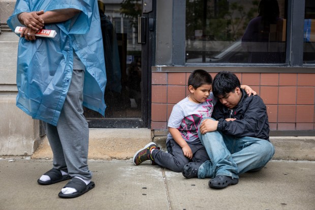 Two boys cry after their mother was taken away in a van by federal agents on June 4, 2025, outside a Intensive Supervision Appearance Program office run by Immigration and Customs Enforcement in the South Loop. (Brian Cassella/Chicago Tribune)