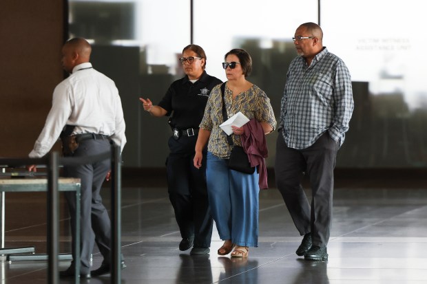 A Chicago police officer escorts family members of Officer Krystal...