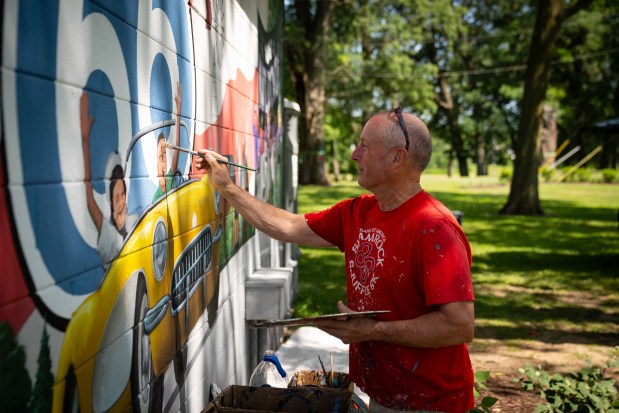 Robert Ryan paints new Route 66 murals near the refurbished Gemini Giant in South Island Park in Wilmington, Illinois, June 21, 2025. (E. Jason Wambsgans/Chicago Tribune)