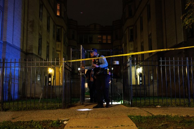 Chicago police officers search a residential building at the scene...