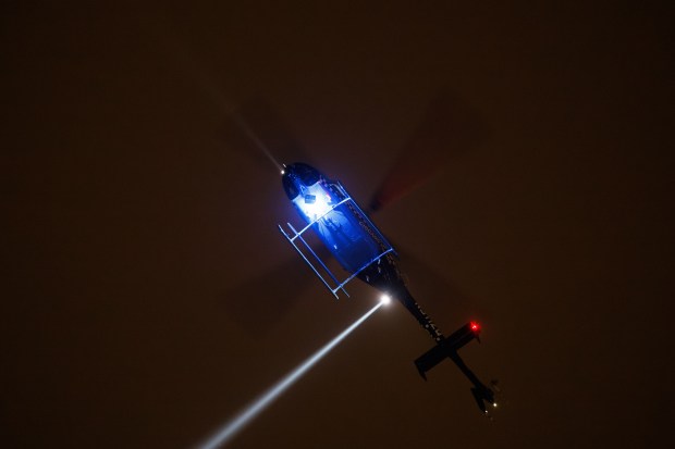 A police helicopter flies over the scene where Officer Krystal...