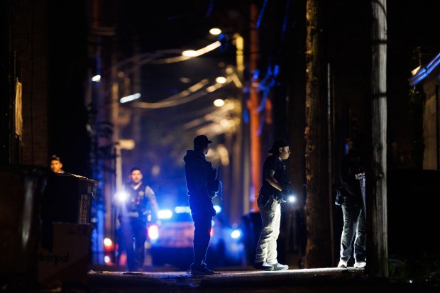Police search an alley at the scene where Officer Krystal...