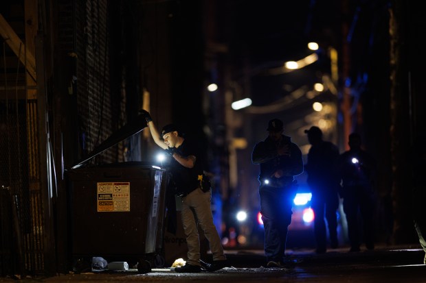 Police search an alley at the scene where Officer Krystal...