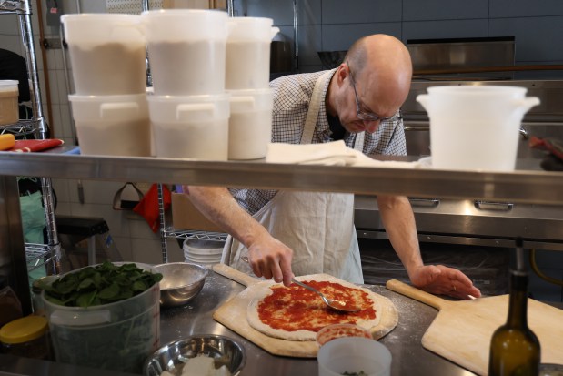 Owner Nick Lessins prepares a pizza at Great Lake on June 24, 2025. (Antonio Perez/Chicago Tribune)